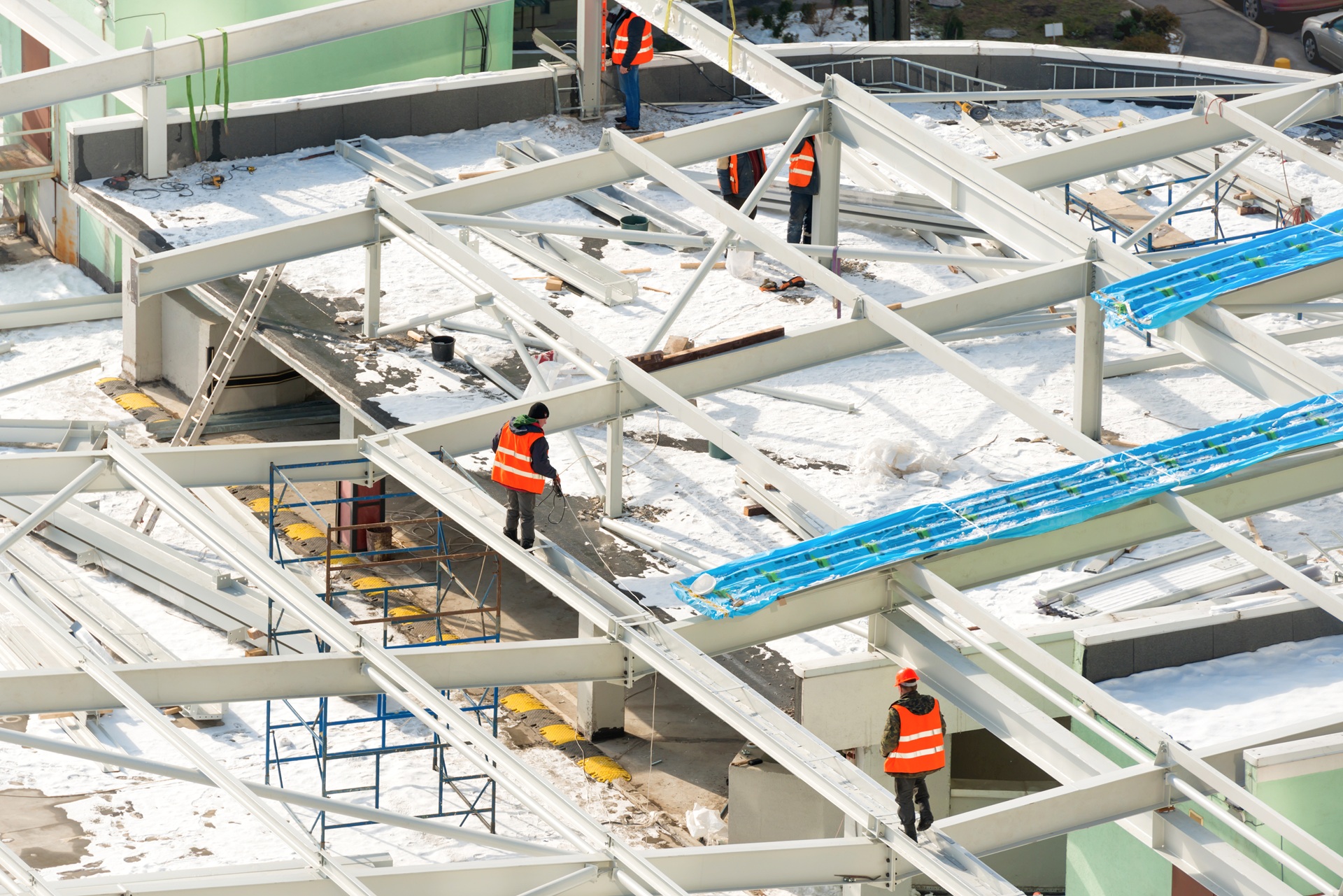 Arbeiter auf Stahlgerüst mit Schnee auf der Baustelle | Heizanhänger mieten
